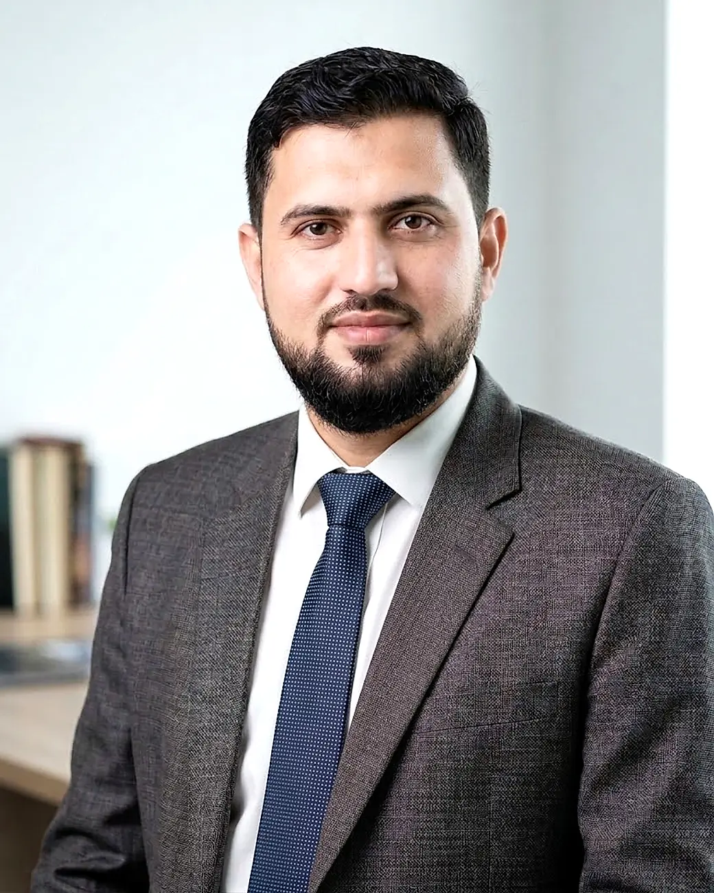 Professional portrait of an ML Data House team member in a grey suit and blue tie